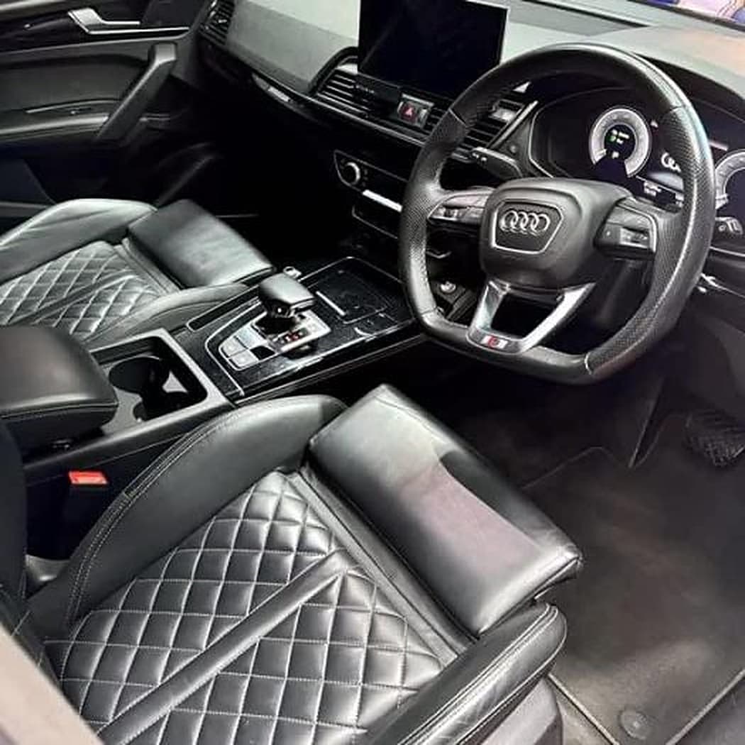 A clean black leather car interior with diamond-stitched seats